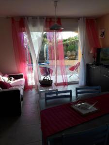 Una sala de estar con un sofá y una mesa y una ventana. en Residence Sejoina, en Calcatoggio