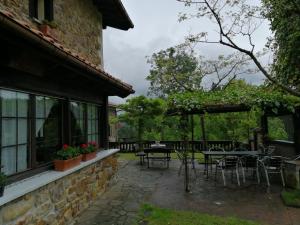 a patio with tables and chairs next to a building at Agroturismo Iturbe in Axpe de Busturia