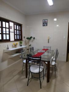 une salle à manger avec une table et des chaises en verre dans l'établissement Casa Beatles Hostel Bauru, à Bauru