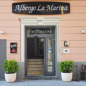 drzwi do baru z dwoma roślinami przed nim w obiekcie Albergo La Marina B&B w mieście Deiva Marina