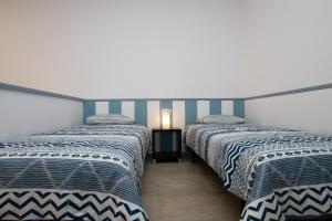 2 Betten in einem Zimmer mit blauen und weißen Streifen in der Unterkunft Atlantic Loft in Puerto del Rosario