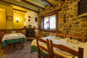 a restaurant with two tables and a stone wall at CASA RURAL BARAZAR in San Sebastián