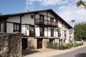 a white and black building with a balcony at CASA RURAL BARAZAR in San Sebastián