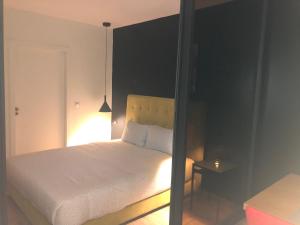 a bedroom with a white bed and a black wall at Cosy Appartment in Rabat