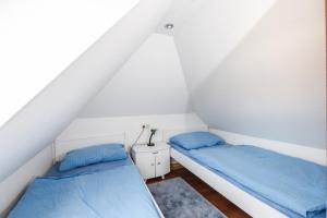 2 Betten in einem Dachzimmer mit blauer Bettwäsche in der Unterkunft Schierke Ferienwohnung Hirschrudel in Schierke