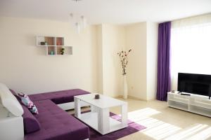 a living room with a purple couch and a tv at Rusalka Apart-Residence in Obzor