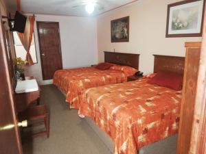 a hotel room with two beds with orange sheets at Hotel Villa De Las Flores in Zacatlán +52 photos