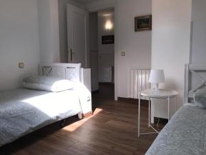 ein Schlafzimmer mit 2 Betten und einem Tisch mit einer Lampe in der Unterkunft Apartamento en Centro Historico de San Lorenzo de El Escorial in San Lorenzo de El Escorial