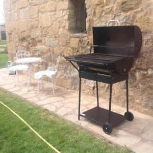 um piano preto num pátio com uma mesa e cadeiras em Finca el Consul em Logroño