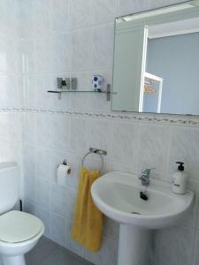 a bathroom with a sink and a toilet and a mirror at La Clinica in Ballota +16 photos