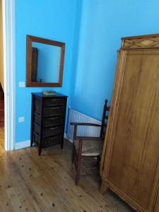 a room with a mirror and a chair and a dresser at La Clinica in Ballota