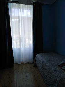 a bedroom with a bed and a white window at La Clinica in Ballota