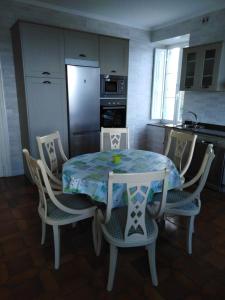a kitchen with a table and chairs and a kitchen with a refrigerator at La Clinica in Ballota