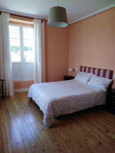 a bedroom with a bed and a large window at La Clinica in Ballota