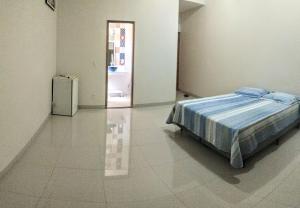 a bedroom with a bed and a refrigerator at Orla Graciosa in Palmas