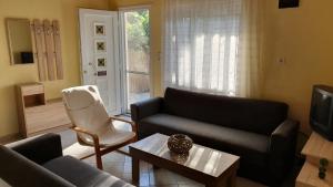 uma sala de estar com dois sofás e uma televisão em christos cottage! comfortable and quiet! em Keramoti