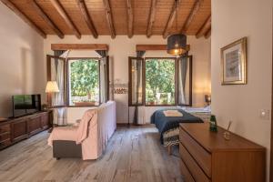 a large living room with a bed and a couch at El Molino del Corcho in Cazalla de la Sierra