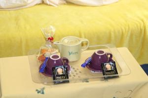 a tray with two cups and a tea set on a table at Au bonheur de LILI in Fontaine-de-Vaucluse