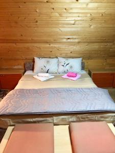 a bed in a wooden room with two towels on it at Villa ORKA Pelister - Forest Zone in Bitola