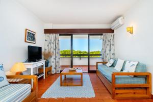 een woonkamer met een bank en een tv bij WHome | Vilamoura Sunny Apartment in Quarteira
