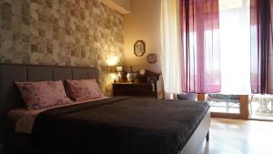a bedroom with a bed with pink pillows at 160 degrees in Tbilisi City