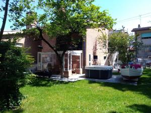 a yard with a tree and a tub in the grass at B&B and Sail in Caorle