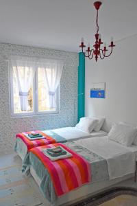 een slaapkamer met 2 bedden en een kroonluchter bij Short Stay Studio in Thessaloniki