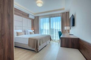 a bedroom with a bed and a desk and a window at Hotel Twelve by Aycon in Budva