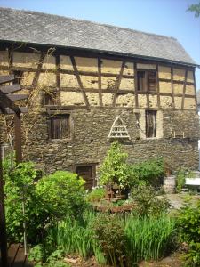 an old stone house with some plants in front of it at Ferienhaus Haus am Pütz in Wintrich