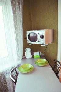 ein Tisch mit zwei grünen Tellern und einer Mikrowelle in der Unterkunft 1 комнатная квартира, левый берег, Пр Калнышевского, пр Слобожанский, 6 городская клиника in Nizhnedneprovsk