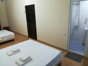 una camera con doccia e un letto con due asciugamani di West House a Kobuleti