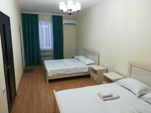 una piccola stanza con due letti e una finestra di West House a Kobuleti