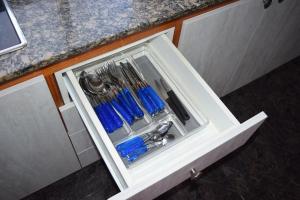uma gaveta branca com utensílios azuis em B&B La Caleta Zimmer 1 (10 min. von El Medano) em La Mareta