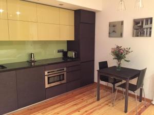 a kitchen with a black table and a table and chairs at Comodidad y diseño en el centro de Oviedo Registro de turismo VUT 75 AS in Oviedo