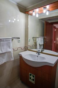 een badkamer met een wastafel en een spiegel bij CASA GRAZINA in Boliqueime
