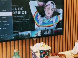 un tavolo con una ciotola di popcorn e un poster di un film di Laguna Beach Flat a Porto De Galinhas