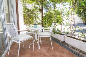 una mesa y 2 sillas en un patio con ventana en Apartments Terra, en Biograd na Moru