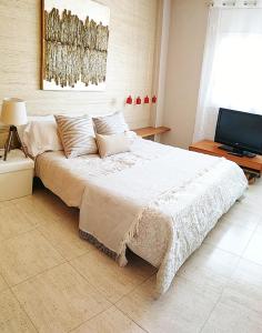 a large bed in a room with a television at tarragonaapartments Fortuny Reus in Reus