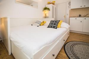 Una cama blanca con almohadas en la cocina en Apartments Terra, en Biograd na Moru