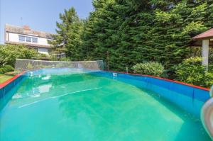 a swimming pool in a backyard with a blue swimming pool at Pokoje Olech in Wrzosowo