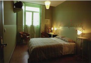 sypialnia z łóżkiem i oknem w obiekcie Hostal Fornos w mieście Segovia