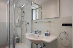 a white bathroom with a sink and a shower at Flat Six in Rome