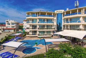 a hotel with a swimming pool in front of a building at Семеен хотел Адена in Chernomorets