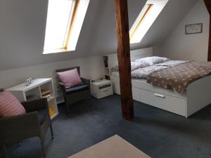 a bedroom with a bed and a desk and windows at Ferienwohnung am Hohen Elbufer in Coswig
