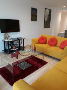 a living room with a yellow couch and a coffee table at Canovas by the Bull Ring in Málaga