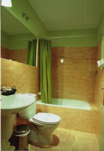 La salle de bains est pourvue de toilettes, d'un lavabo et d'une baignoire. dans l'établissement Hostal Fornos, à Ségovie