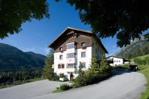 un grand bâtiment blanc avec un toit marron dans l'établissement Hotel Zita, à Trins