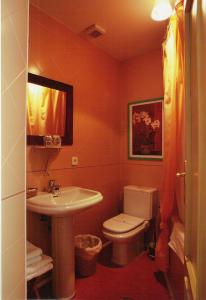 a bathroom with a toilet and a sink at Hostal Fornos in Segovia