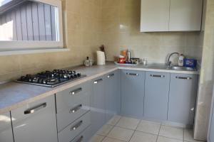 a white kitchen with a stove and a sink at Три кошки in Chornomorsk