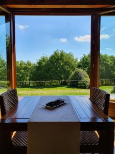 a table with two chairs and a large window at Rectoral De Lestedo in Palas de Rei